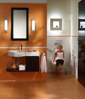 In kleinen Bädern können Wandleuchten als Allgemeinbeleuchtung dienen. Eine Deckenleuchte ist in diesem fall nicht nötig. Das hinerleuchtete Bild über dem WC setzt einen zusätzlichen Akzent.