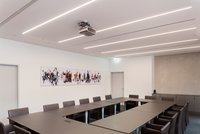 Im Schulungsraum verlaufen elegante, in die Decke eingelassene Lichtbandsysteme quer zur Raumrichtung.