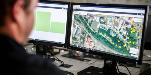 Ein unscharf im Profil abgebildeter Mann betrachtet in seinem Notebook ein Programm, mit dem die Lichtsteuerung verwaltet wird.