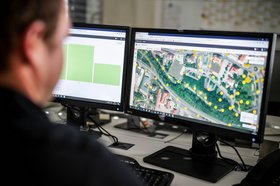 Ein unscharf im Profil abgebildeter Mann betrachtet in seinem Notebook ein Programm, mit dem die Lichtsteuerung verwaltet wird.