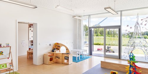 Das Spielzimmer eines Kindergartens mit Akustikdecke und Pendelleuchten