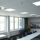 Ein Besprechungsraum mit quadratischen Einbauleuchten und einem Sensor an der Decke