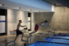 Die Beleuchtung sorgt im Schwimmbad für Sicherheit: Lehrer, Trainer, Bademeister und Schiedsrichter müssen Bewegungen und Mimik der Schwimmer schnell und sicher erkennen können. Badende müssen Beckenrand, Bahnmarkierungen, Mitschwimmer und Bälle sehen können. (Foto: licht.de/Erco, Fotografie: Sebastian Mayer)