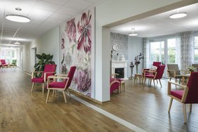 Die Beleuchtung von Fluren in Pflegeeinrichtungen dient auch der Sturzprävention. Eine Lichtanlage nach dem Planungskonzept Human Centric Lighting im Tagesraum stärkt den Schlaf-Wach-Rhythmus und trägt zum Wohlbefinden bei. (Foto: licht.de/Derungs)